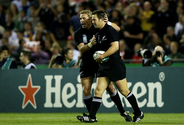 MELBOURNE, AUSTRALIA - NOVEMBER 8: Leon MacDonald of New Zealand is congratulated by team mate Justin Marshall after his try during the Rugby World Cup Quarter Final 1 match between New Zealand and South Africa at the Telstra Dome November 8, 2003 in Melbourne, Australia. (Photo by Daniel Berehulak/Getty Images for Heineken)